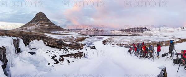 Many photographers photograph Mount Kirkjufell with frozen waterfall Kirkjufellfoss