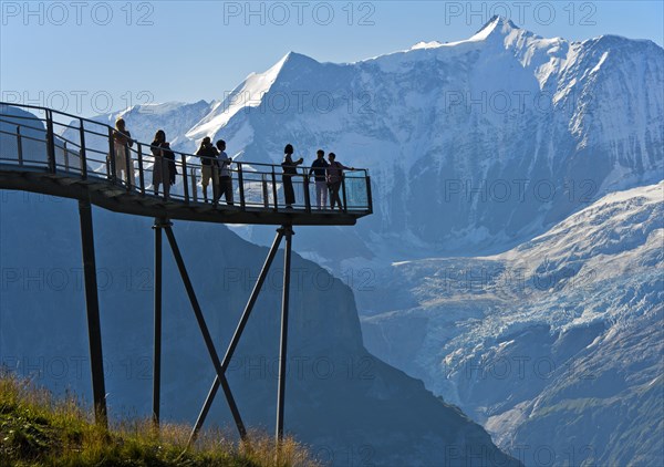 Tourists on the observation deck of the First Cliff Walk by Tissot in front of the Fiescherhorn north face and the Grindelwald glacier