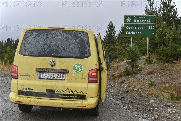 Yellow travel minibus on the Carretera Austral at Cochrane at road sign