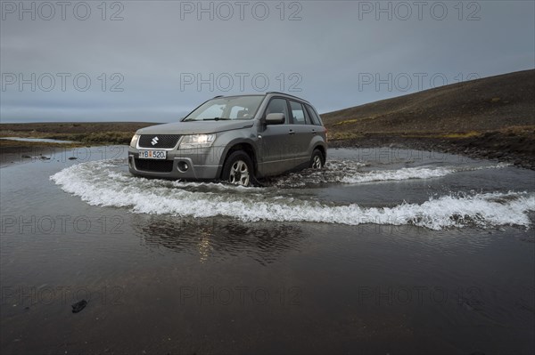 Off road vehicle drives through waterfurt