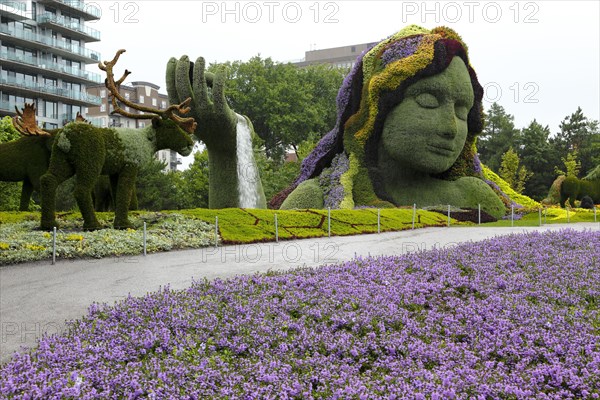 Plant sculpture Mother Earth with modern buildings behind