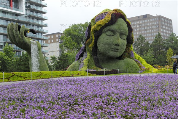 Plant sculpture Mother Earth with modern buildings behind