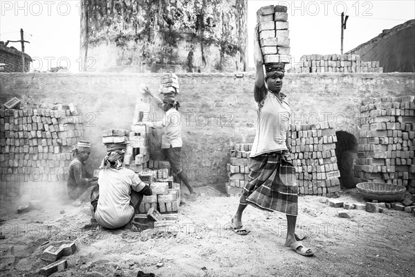 Workers with bricks on their heads in the brickyard