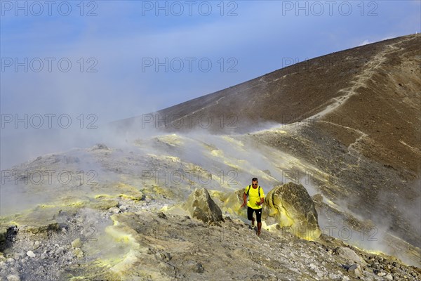 Trailrunner surrounded by sulfur fumaroles and chloride crusts on the crater rim