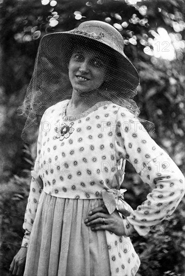 Woman with hat and mosquito net on her face