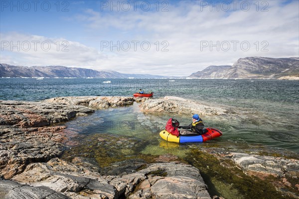 Two persons with packing trucks on fjord