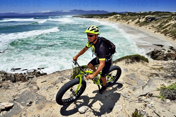 Mountain biker with Fatbike on cliff