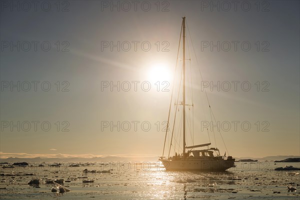 Sailing ship between ice floes in the fjord