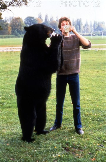 Brown bear and man drink standing