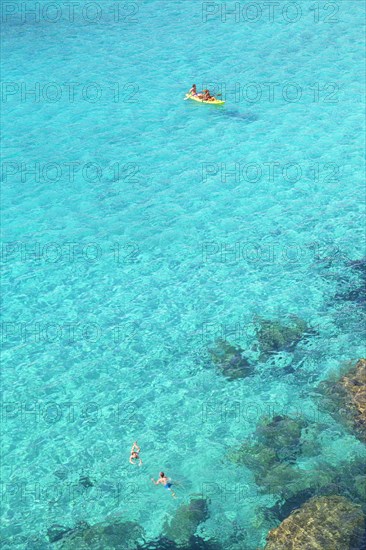 People canoeing and swimming at Cala Mitjana