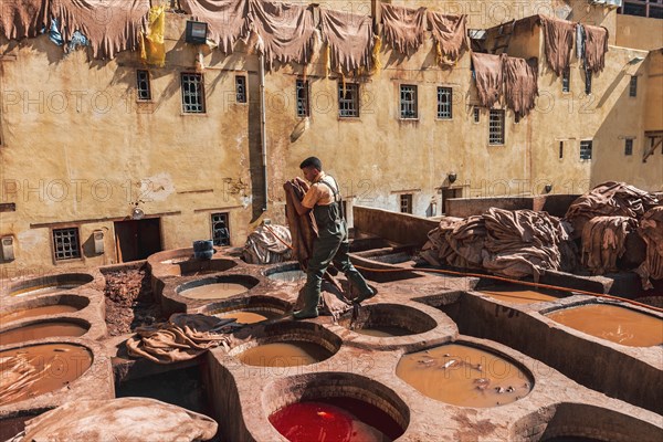 Worker dyeing leather