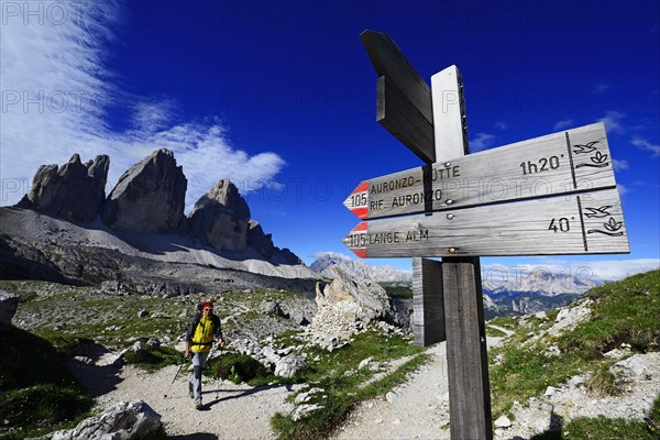 Hiker below the Drei Zinnen-Hutte in front of the northern walls of the Three Peaks of Lavaredo