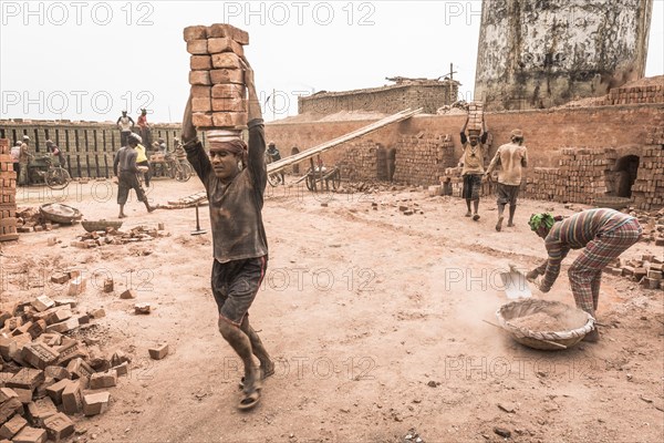 Workers with bricks on their heads in the brickyard