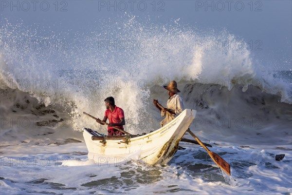 Fishermen in the boat in the surf