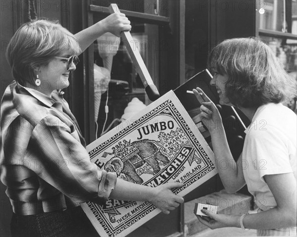 Two women with large matchbox