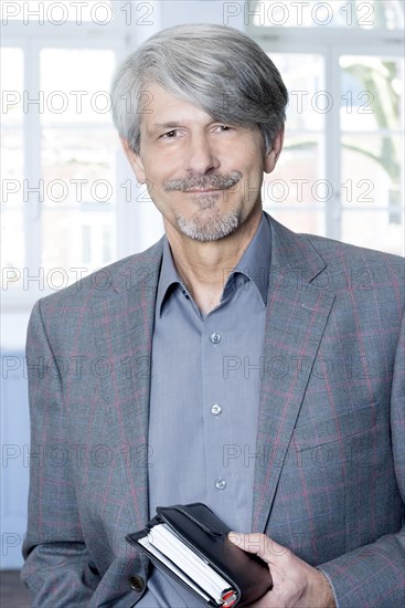 Man with calendar in front of his office window