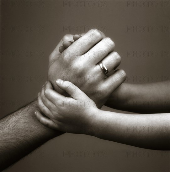 Child's hands holding father's hand