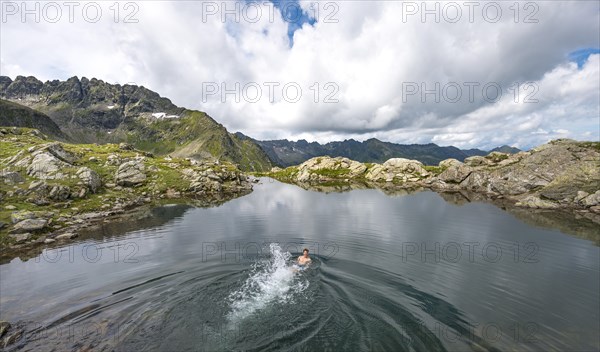 Young man swimming in a small lake