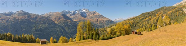 Autumnal mountain landscape with alpine huts