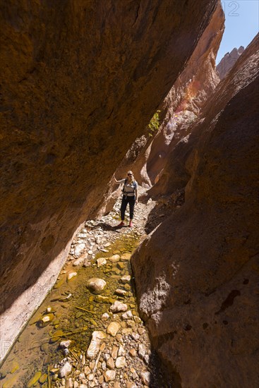 Young female hiker in a narrow sandstone canyon