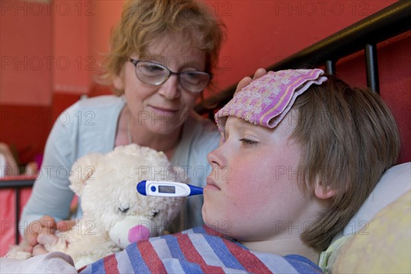 Mother comforts sick son in bed