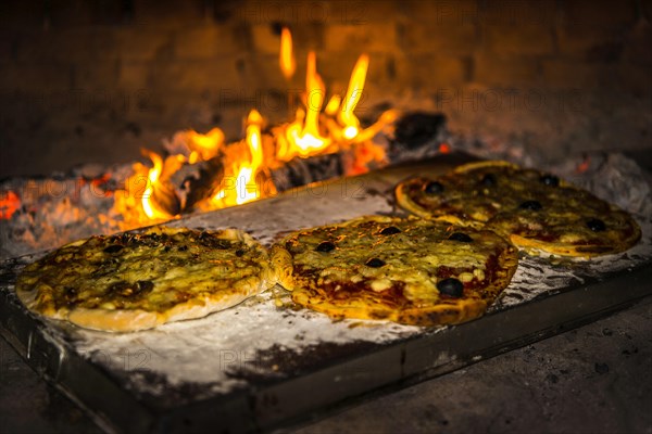 Pizza is baked in a pizza oven