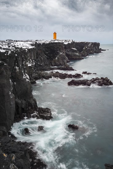 Orange lighthouse Ondverdarnes stands on a dark cliff