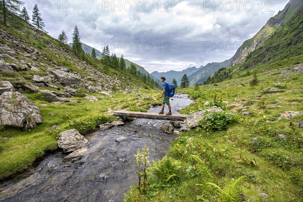 Hiker on a bridge over the Steinriesenbach