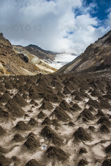 Little sand mounds on a glacier field on Mutnovsky volcano