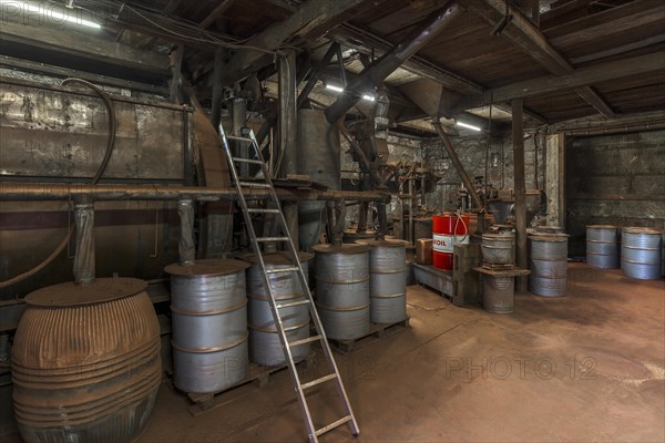 Production room for bronze powder with barrels and machines in a historical metal powder factory