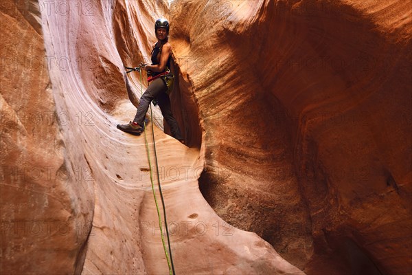 Woman climbing in Huntress Slot Canyon outside Zion National Park