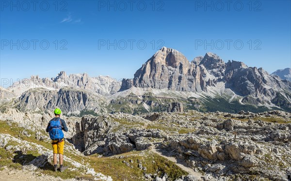 Hiker with climbing helmet on footpath to the Nuvolau