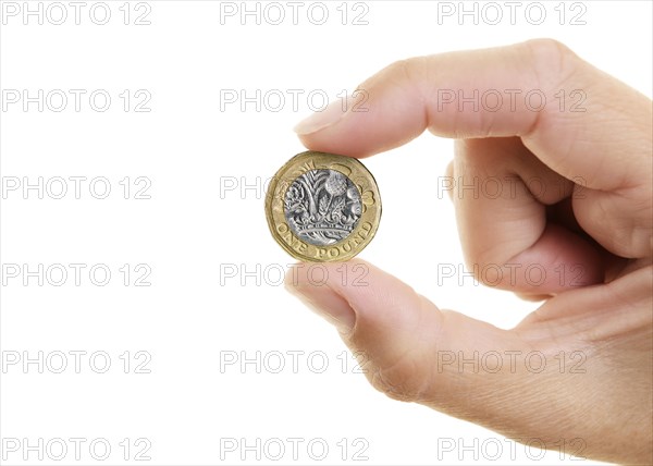 New Pound Coin held between the fingers of a womans hand