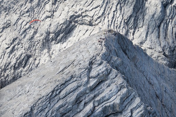 Summit of the Alpspitze in the Wetterstein Mountains with mountaineers in front of the Hochblassen