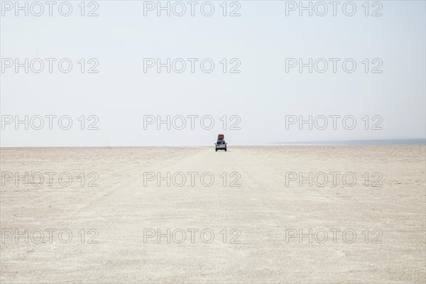 Off-road vehicle drives through the salt desert of Dallol