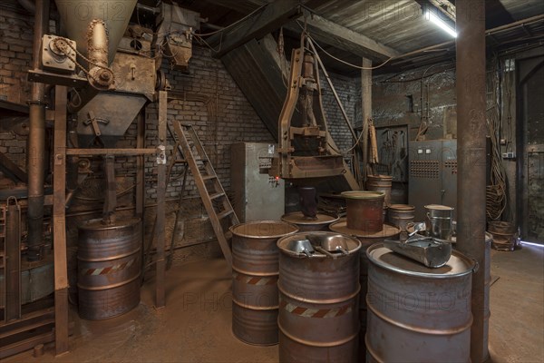 Production room for bronze powder with barrels and machines in a metal powder plant