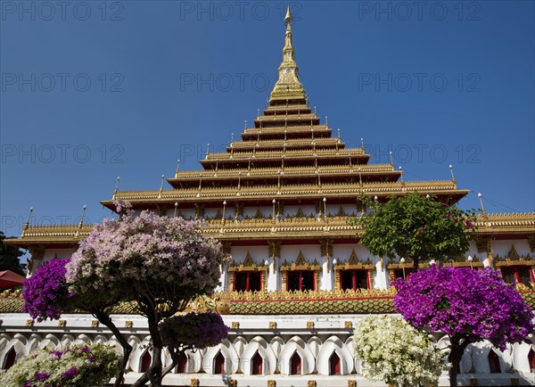 Flowering bushes in front of nine-story stupa Phra Mahathat Kaen Kakhon