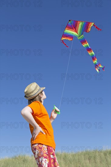 Boy playing with a kite on the beach