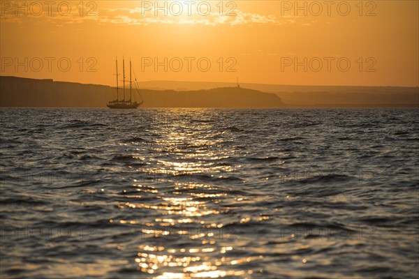 Three masters off the coast at sunrise