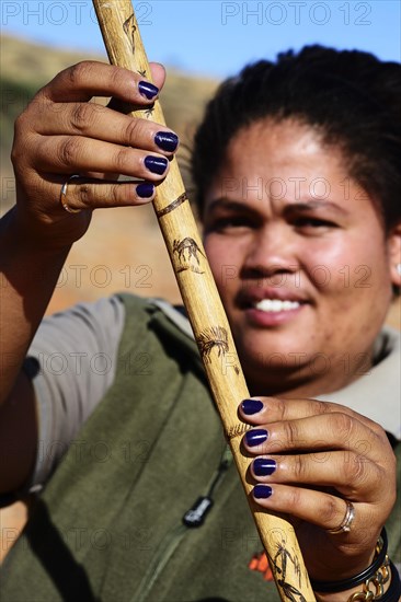 Ranger of the !Xaus Lodge shows her walking stick with aardvark and anteater decoration