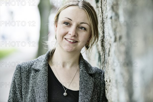 Young woman leaning against a wall