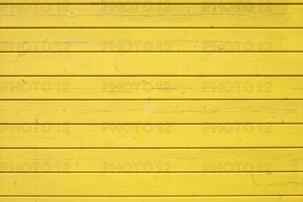 Wooden wall of horizontally arranged yellow painted boards