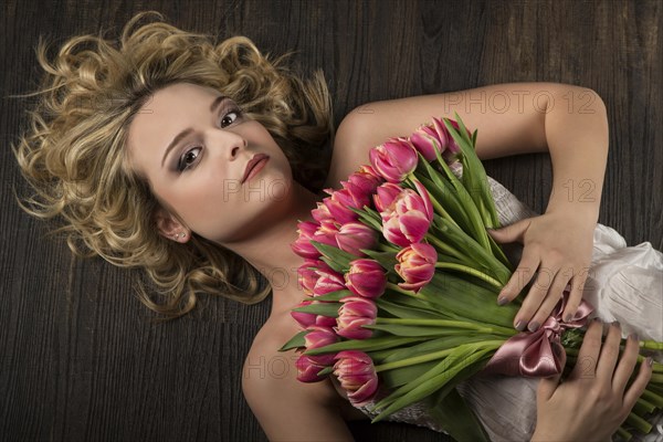 Young woman posing with a bouquet of flowers tulips