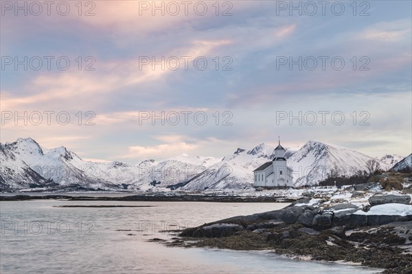 Church of Gimsoy surrounded by snowy mountains and coast