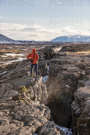 Man stands at Continental Rift between North American and Eurasian Plate