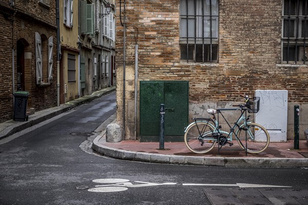 Bicycle parks next to a road surface marking for bicycle lane on a street, Toulouse