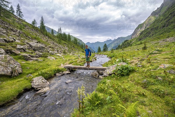 Hiker on a bridge over the Steinriesenbach