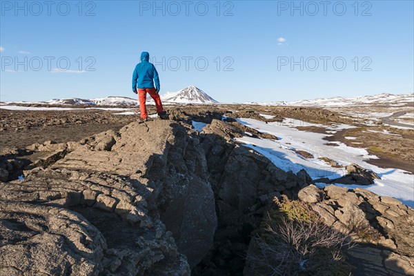 Man stands at Continental Rift between North American and Eurasian Plate