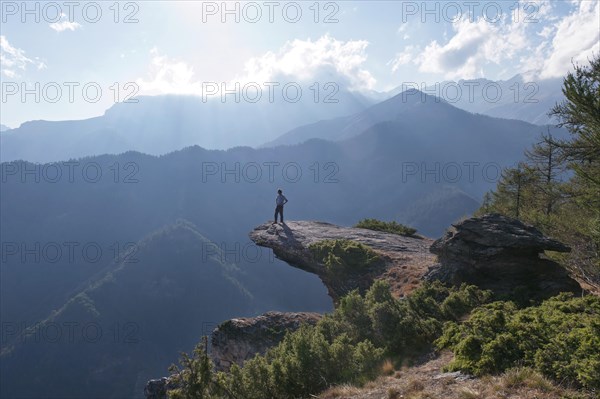 Man standing on prominent protruding rock