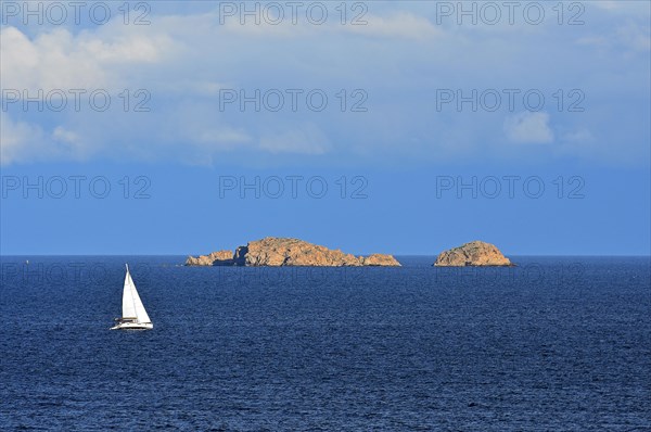 Sailboat in front of rocky islands